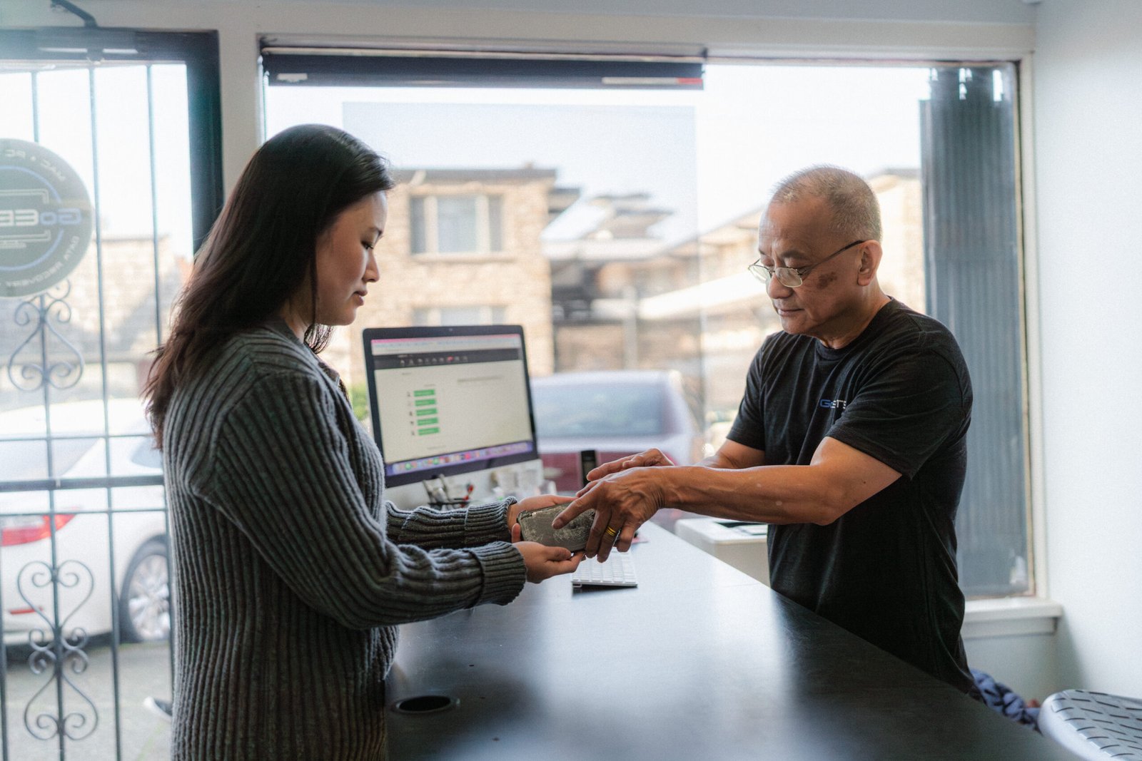 phone and computer repair shop doing customer service with customer repairing an apple iphone