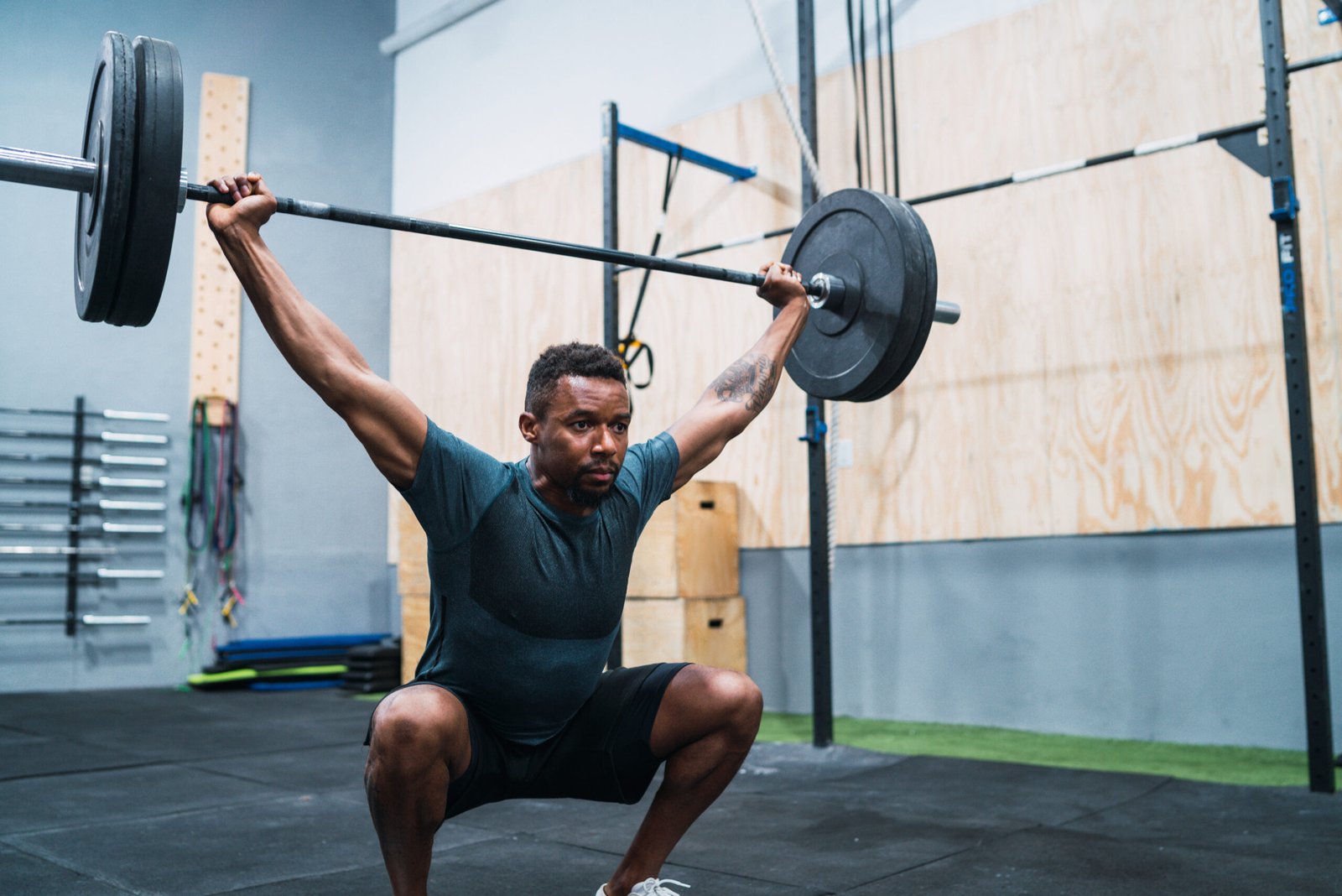 Portrait of young crossfit athlete doing exercise with a barbell. Crossfit, sport and healthy lifestyle concept.